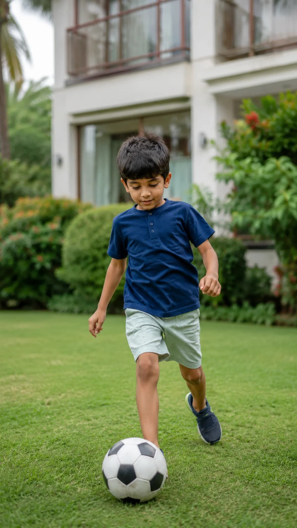 A boy running after a football in the garden